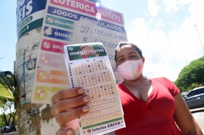 Mulher com bilhete de loteria da Mega-Sena