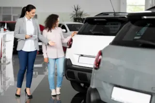 Compradora avalia carro usado em uma concessionária antes de fechar a negociação