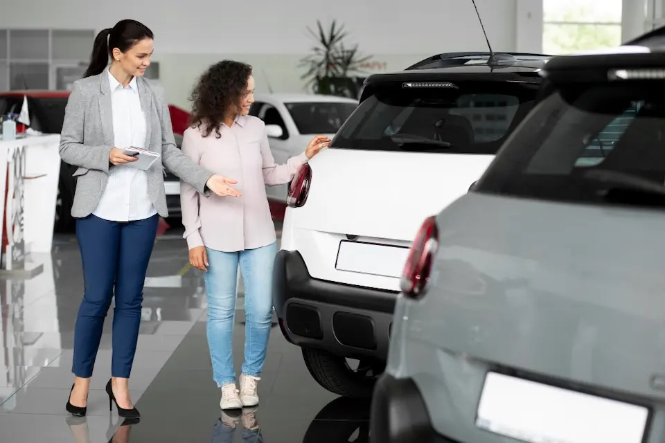 Compradora avalia carro usado em uma concessionária antes de fechar a negociação