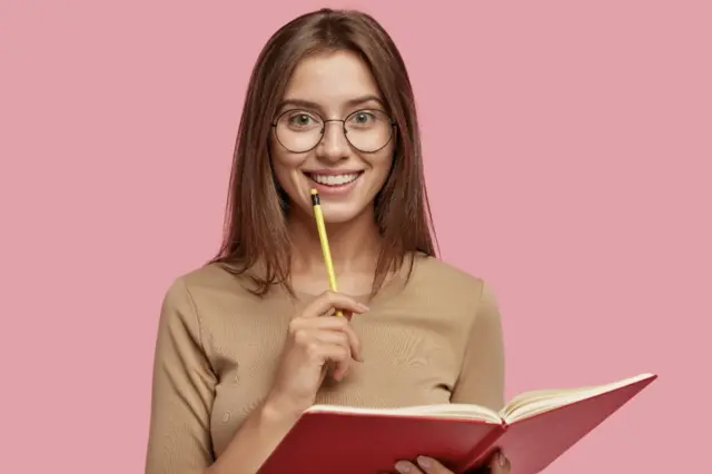 Jovem estudante segurando um livro e um lápis, representando o acesso ao ensino superior