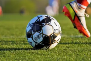 Bola de futebol em campo representando apostas esportivas e casas de apostas legalizadas