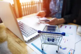Mulher realiza compra online usando cartão e notebook
