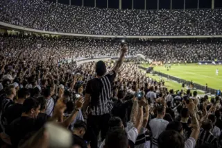 Torcida do Corinthians em estádio com celulares acesos durante manifestação de apoio a jogador