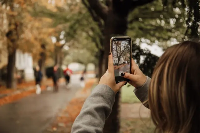 Pessoa fotografa com o celular em reflexão sobre memória e ansiedade