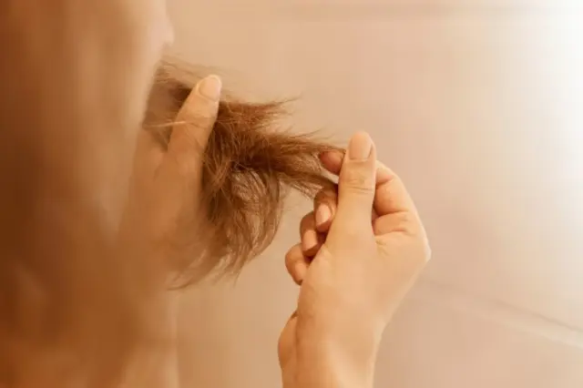 Mãos segurando pontas de cabelo