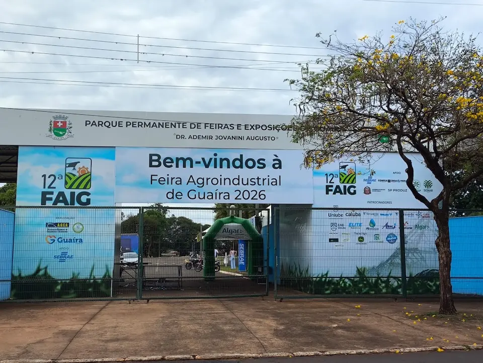 Entrada do Parque Permanente de Feiras e Exposições com faixa 'Bem-vindos à Feira Agroindustrial de Guaíra 2026' sobre o portão
