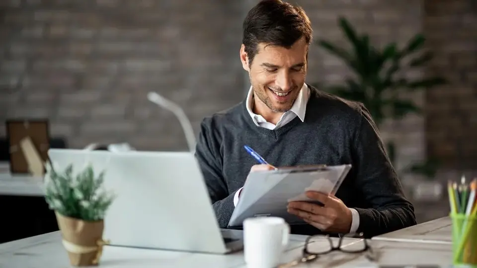 Profissional trabalhando com notebook e anotações em escritório
