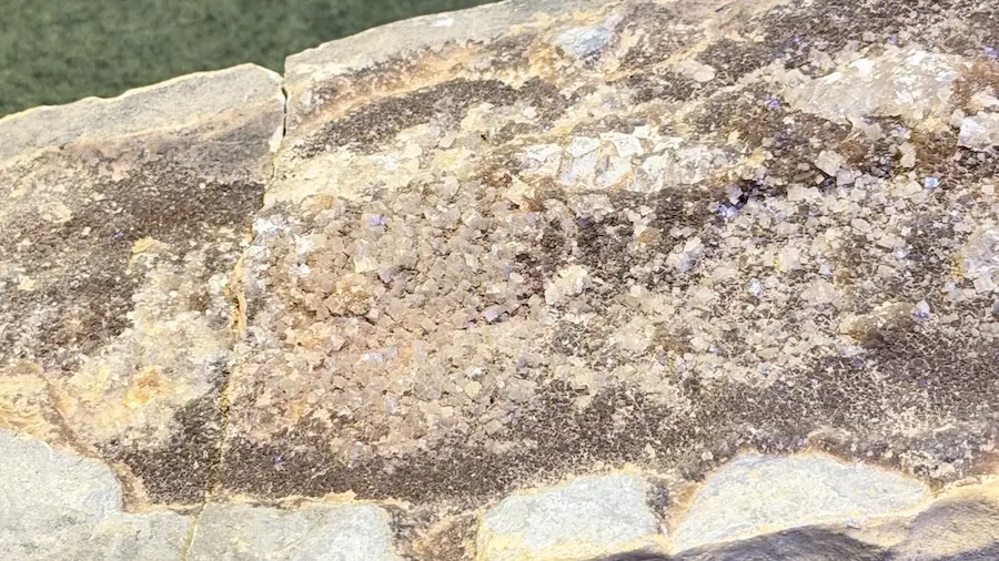 pedra com cristais translúcidos de quartzo sobre matriz rochosa