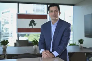Lucas Kallas, empresário ligado à Cedro Mineração, em ambiente corporativo, vestindo terno azul.