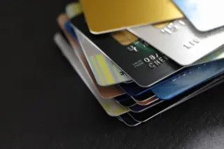 pilha de cartões de crédito e débito coloridos sobre superfície escura