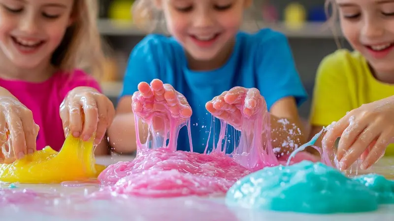 Crianças brincando com slimes coloridos rosa, azul e amarelo sobre mesa