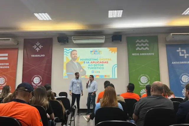 Plateia sentada de costas observa dois palestrantes no palco com telão sobre marketing digital e IA e faixas verticais temáticas nas laterais