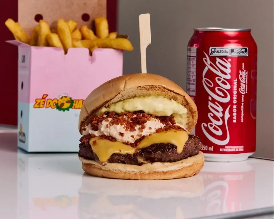 hambúrguer com queijo, alface, tomate e cebola roxa em pão dourado