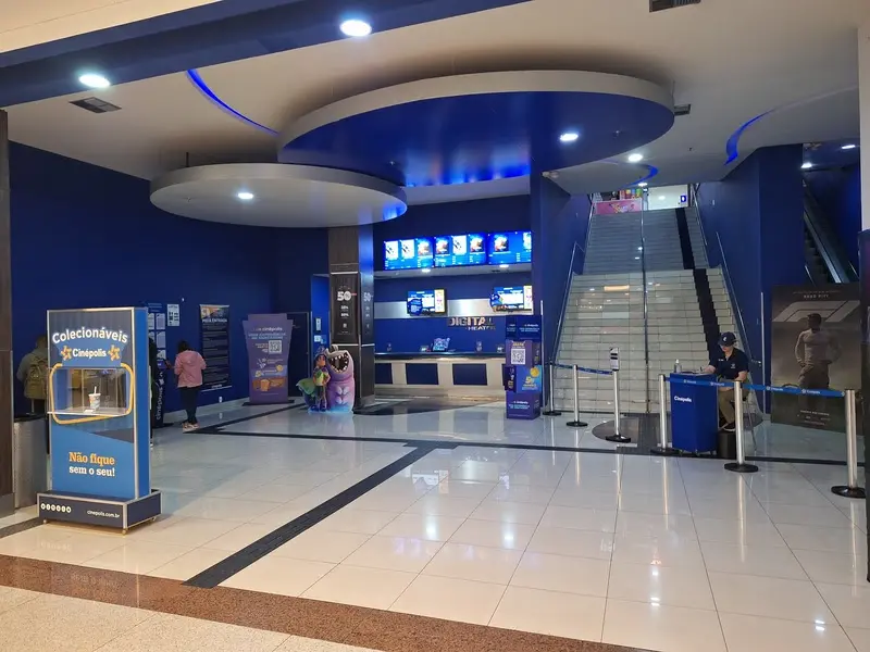 Entrada da Cinépolis no shopping com bilheteria, painéis digitais, balcões e escadas ao fundo