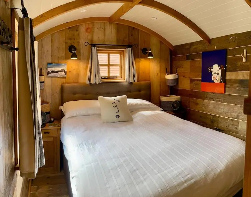 interior rústico de cabana com cama de casal e painéis de madeira curvos