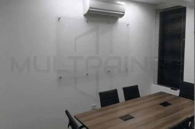 Lousa de vidro transparente instalada na parede de uma sala de reuniões