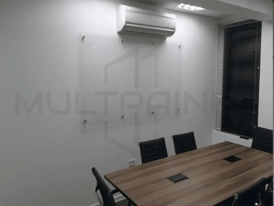 Lousa de vidro transparente instalada na parede de uma sala de reuniões